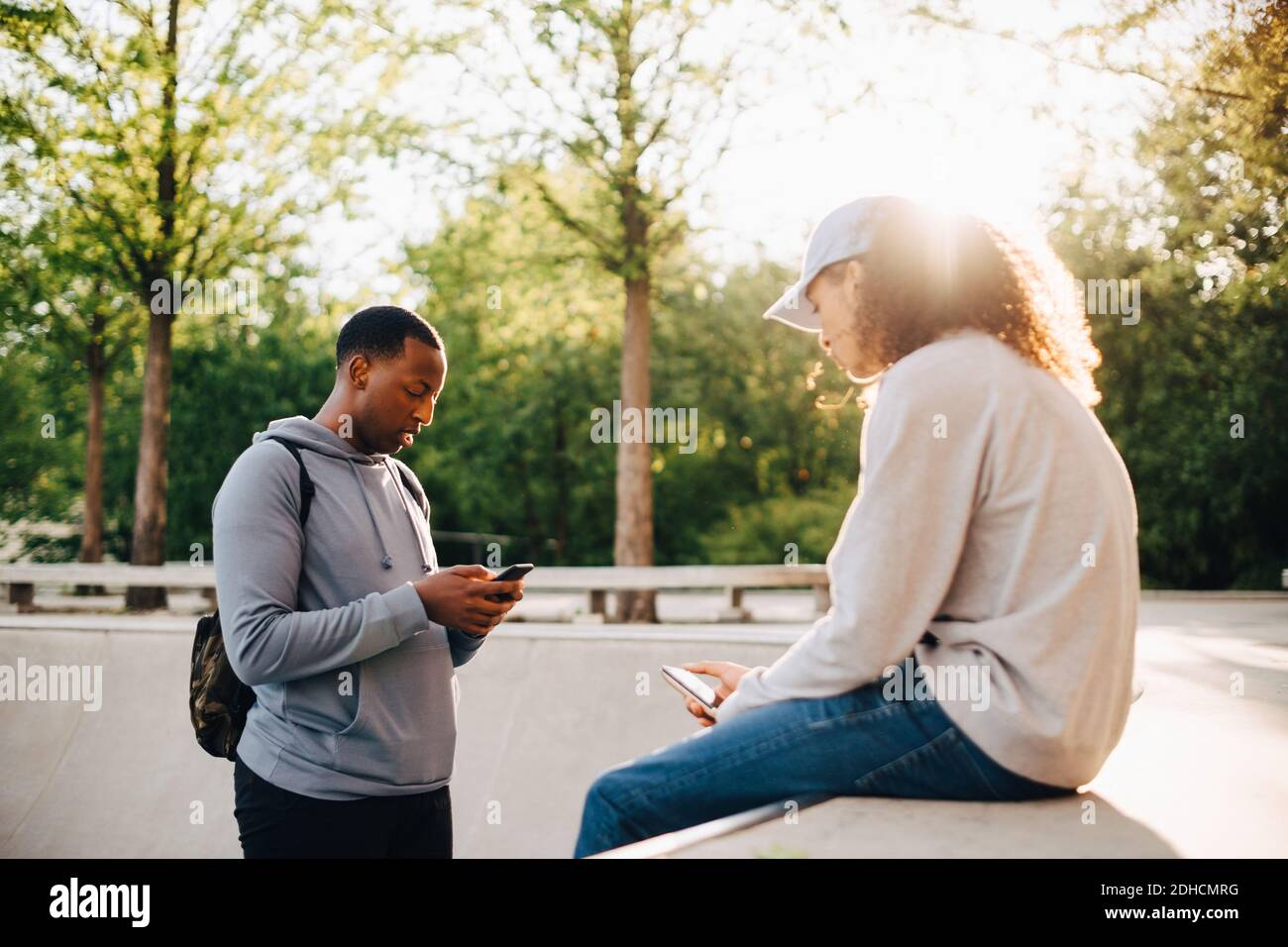 Friends using smart phone at skateboard park Stock Photo