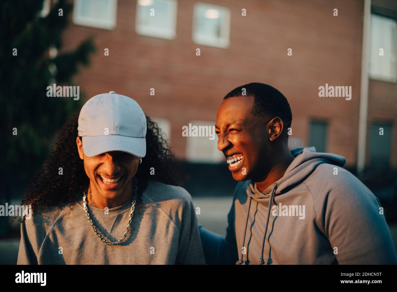 Young friends laughing while talking in city Stock Photo