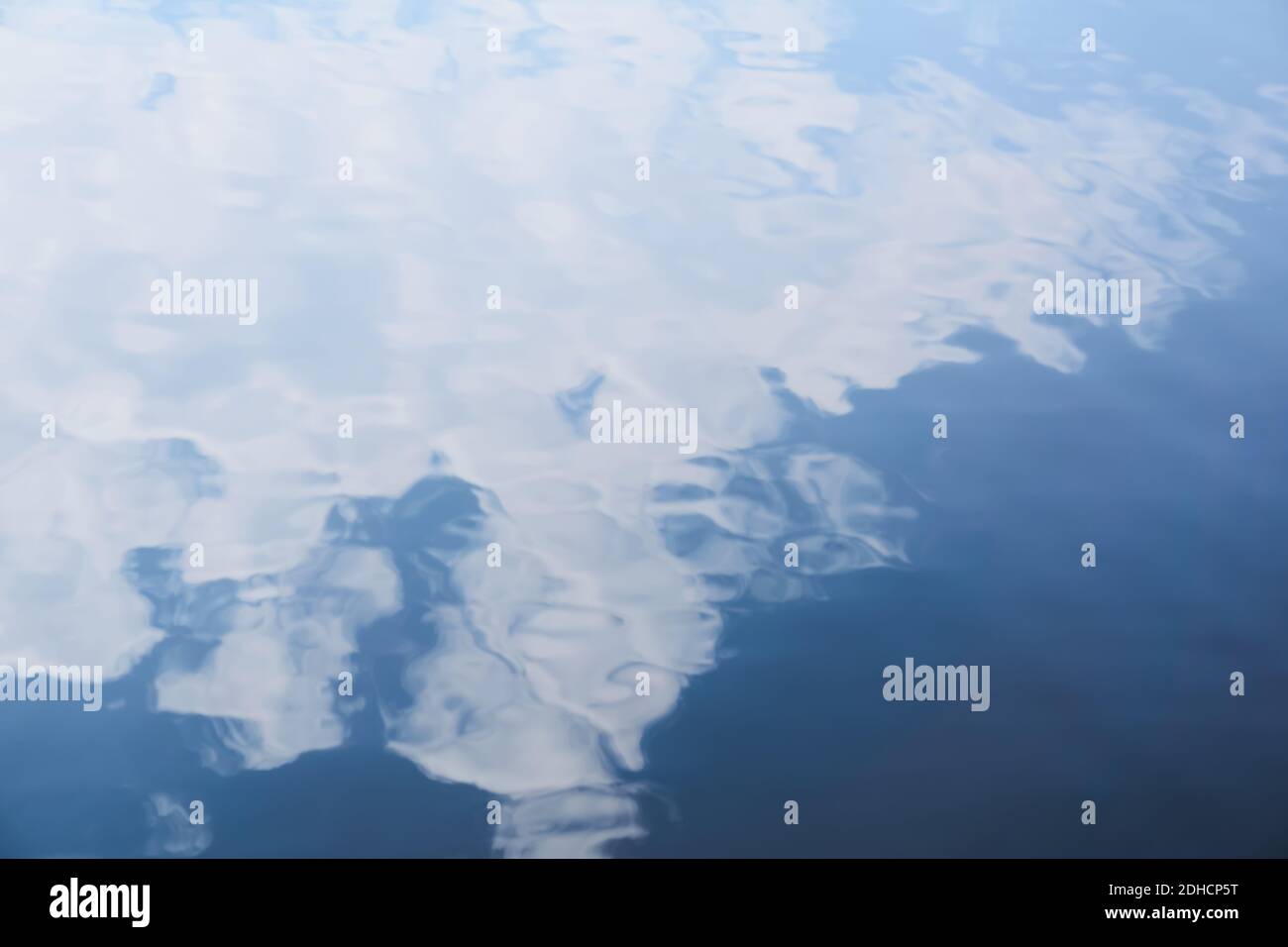 blurred abstract background - soft waves on a smooth water surface with cloud reflection in the sky Stock Photo