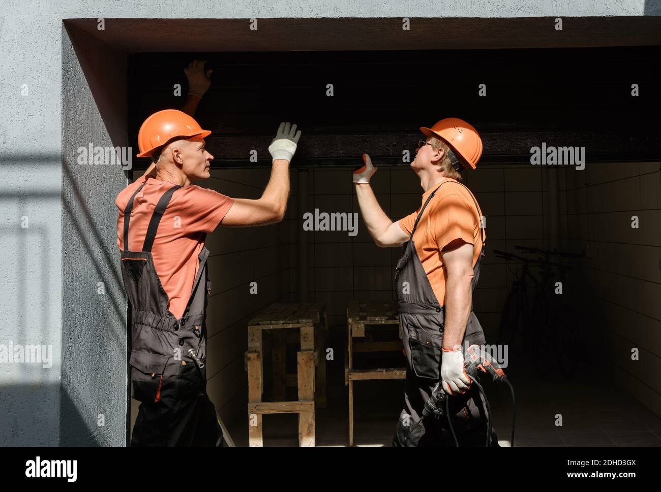 Workers are installing lift gates in the garage. Stock Photo