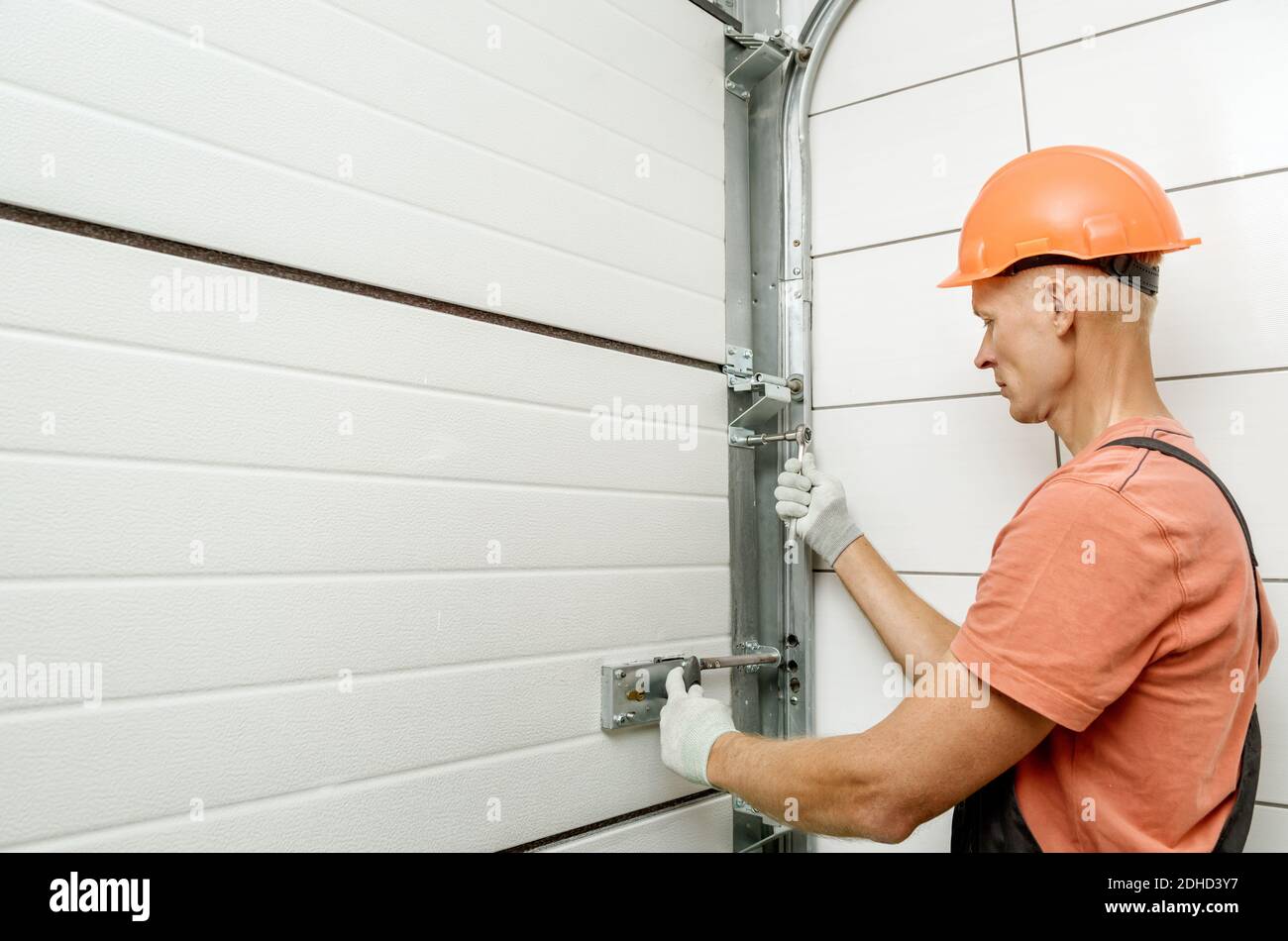 The worker is installing lift gates in the garage. Stock Photo