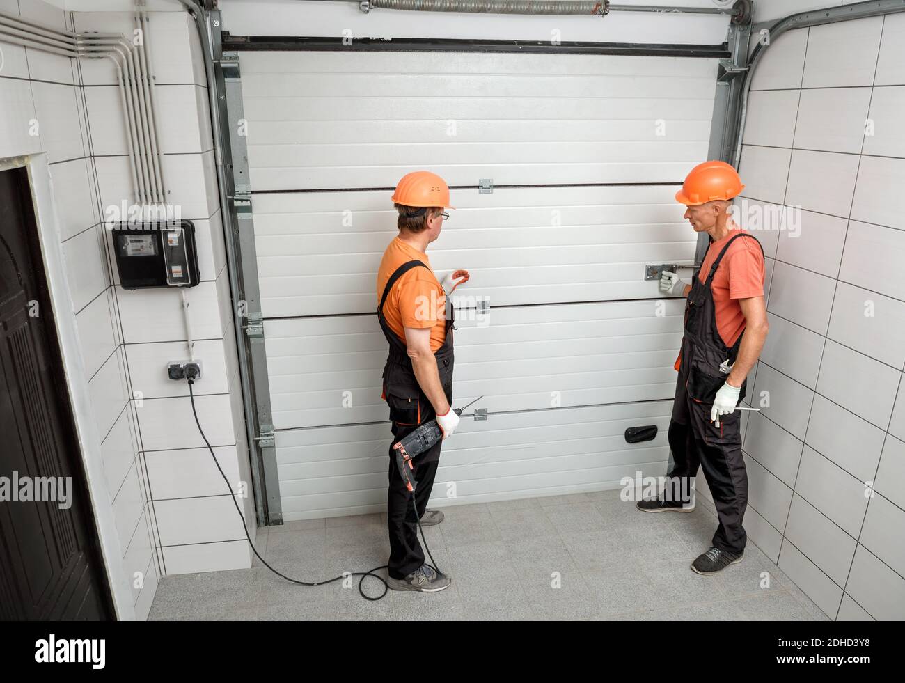 The workers are installing lift gates in the garage. Stock Photo