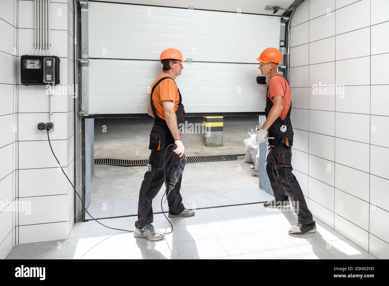 The workers are installing lift gates in the garage. Stock Photo