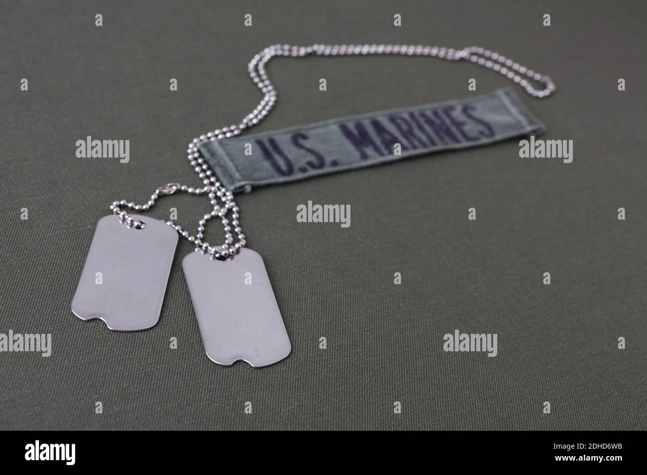 U.S. MARINES Branch Tape with dog tags on olive drab uniform background