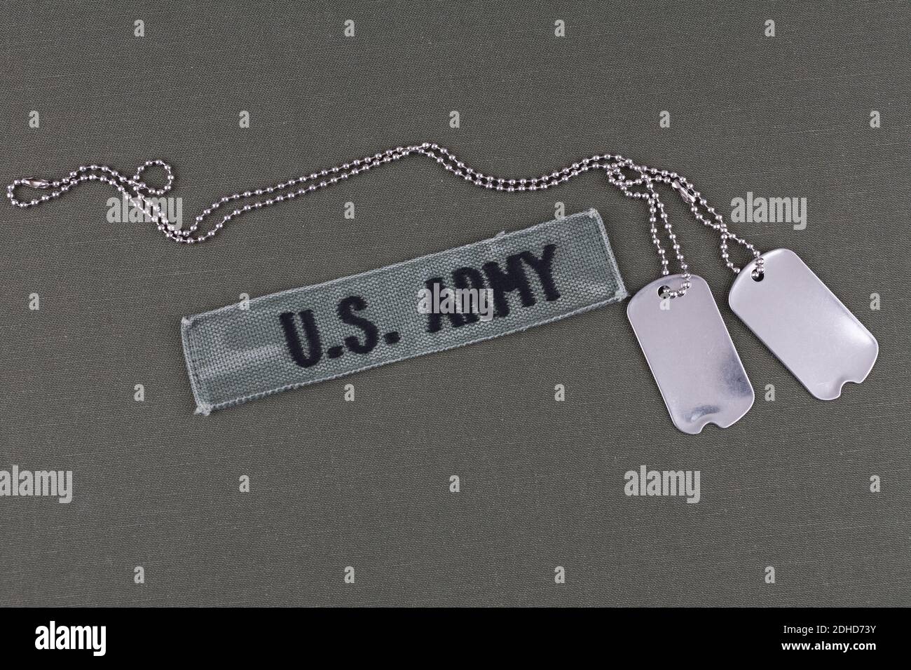 U.S. Army Branch Tape with dog tags on olive drab uniform background ...