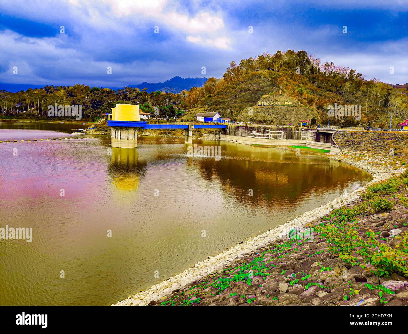 Water reservoir lake with reflections from cloudy sky with small bridge ...