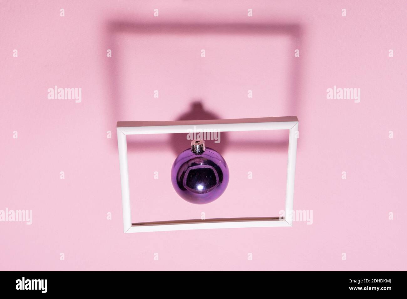 Christmas purple bauble floating in a picture frame with shadows. Abstract Christmas background Stock Photo