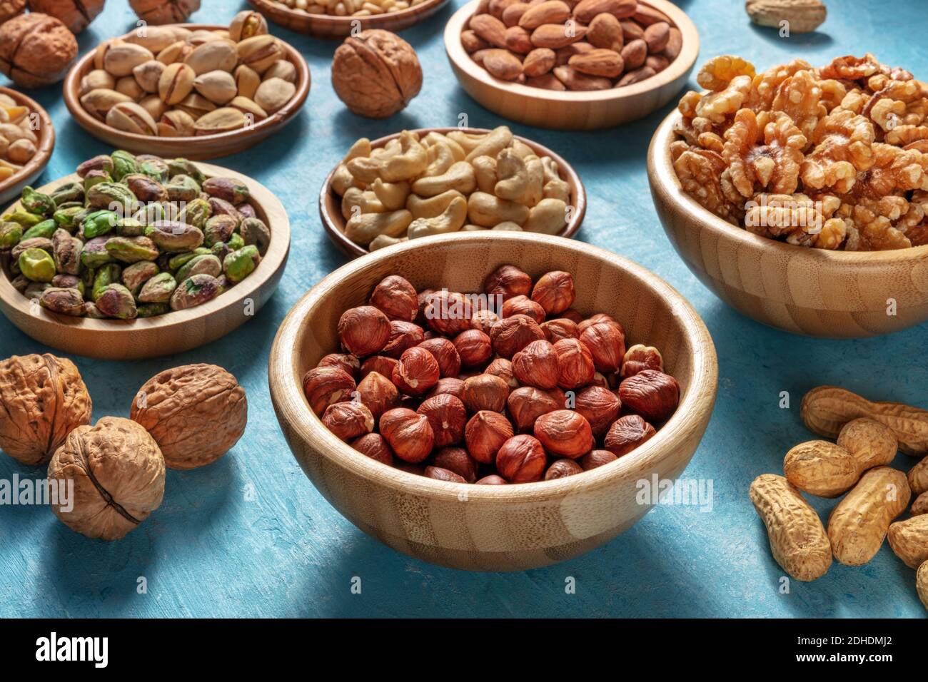 Many different nuts in wooden bowls Stock Photo
