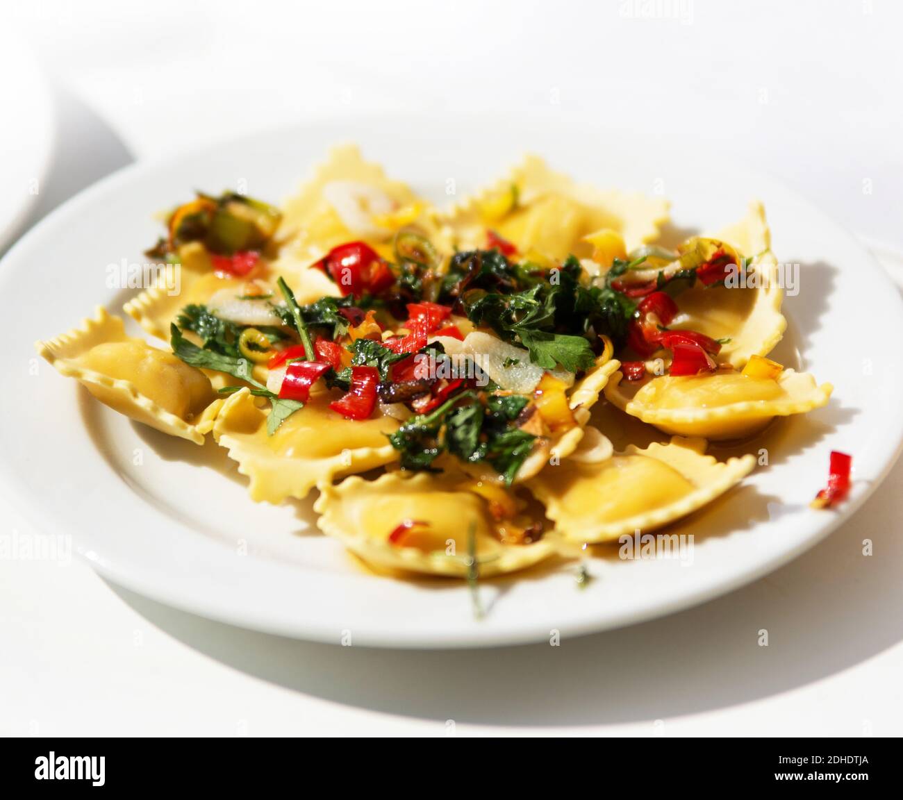 Ravioli garnished with basil leaves on white plate Stock Photo