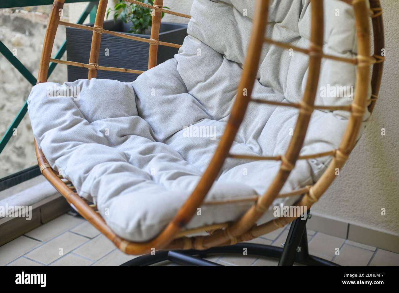 Bamboo chair with gray cushion hanging on the balcony Stock Photo Alamy