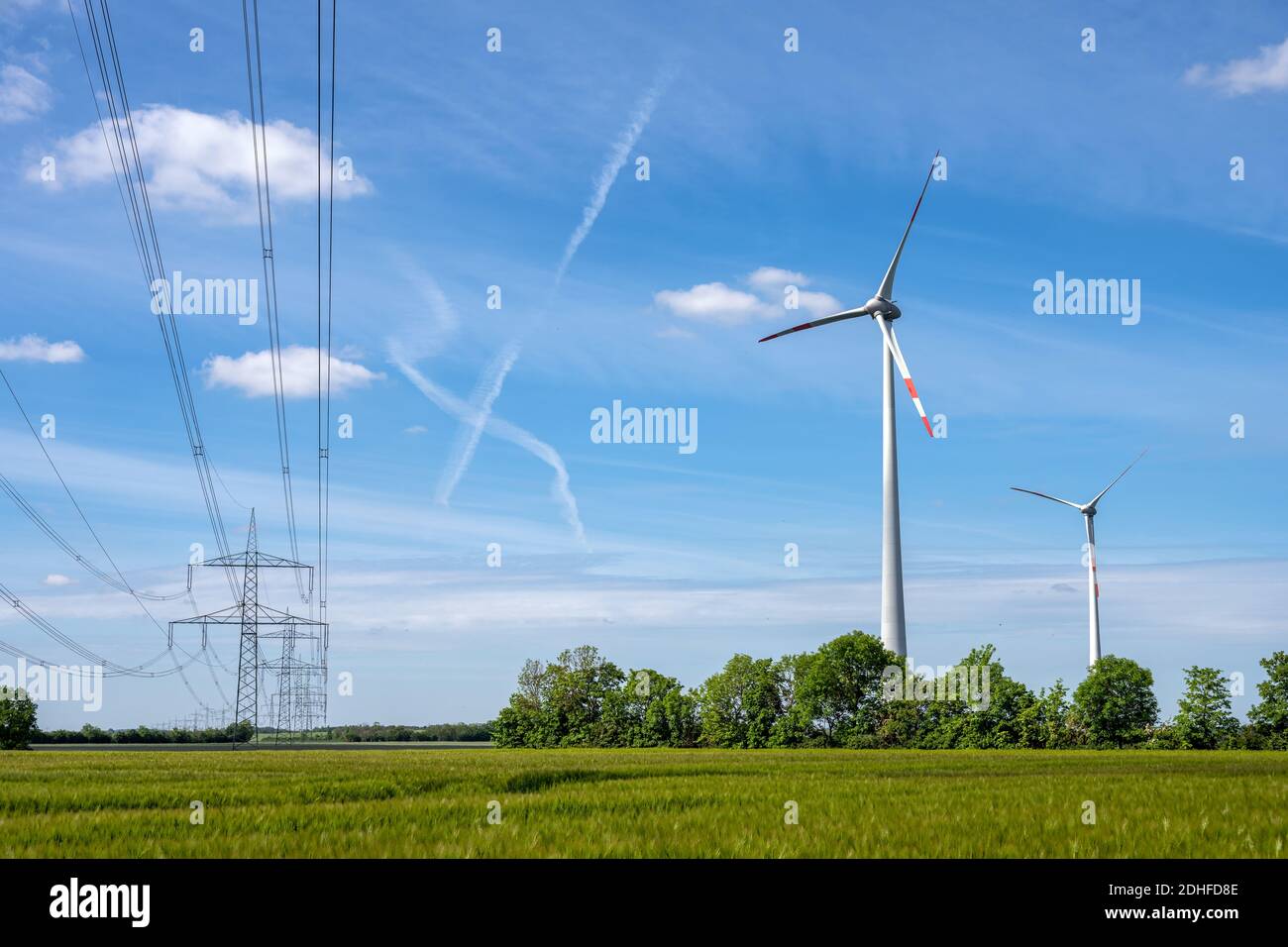 Wind wheels and power lines seen in Germany Stock Photo