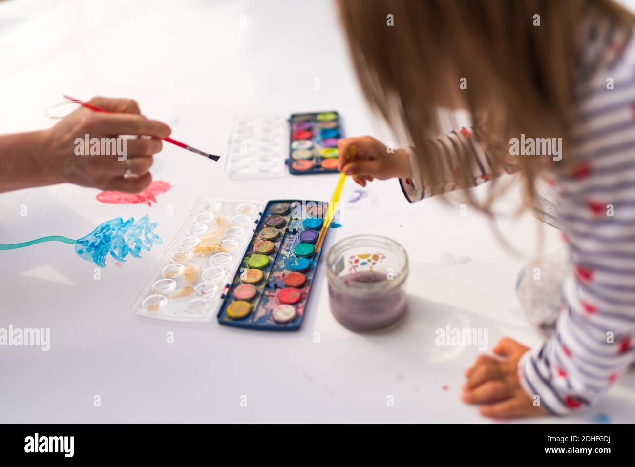 Child With Mother Painting With Poster Paint Outdoors On The Ground On Child with mother painting with poster paint outdoors on the ground on