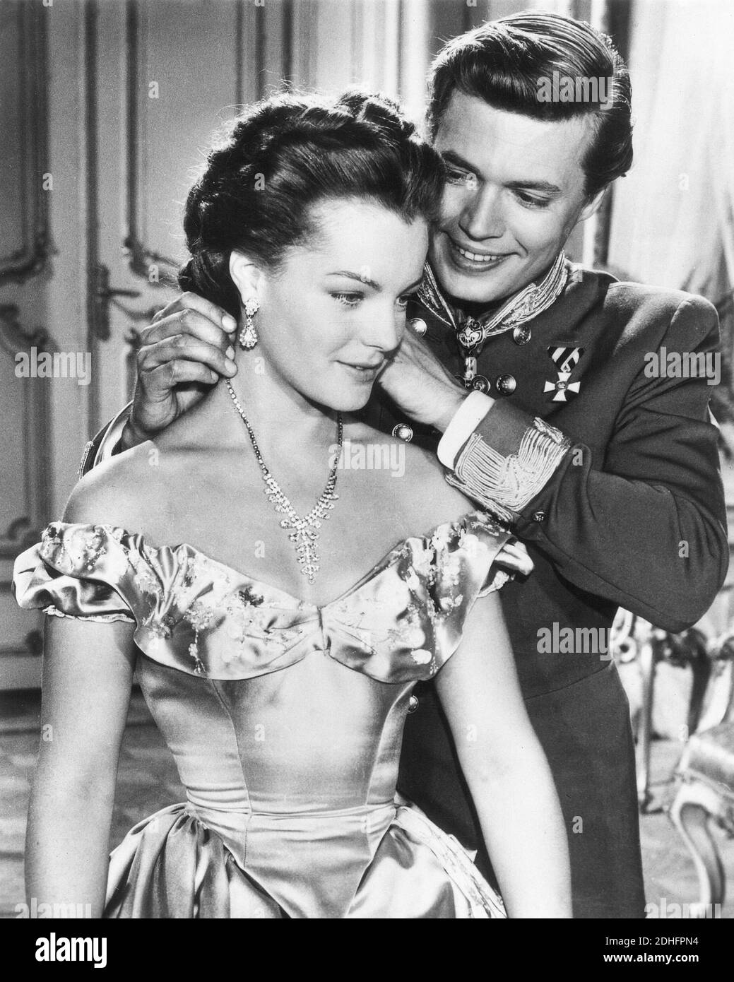 1956 , AUSTRIA :  The movie actress   ROMY  SCHNEIDER ( 1938 - 1982 )  as the Queen Empress SISSI DE JOUNGE KEIZERIN  Elisabeth Absburg of Austria in   '  Sissi  '  by Ernst Marischka , whit her KARL HEINZ BOHM as the Kaiser Franz Josef - ATTRICE - MOVIE - FILM - CINEMA - ASBURGO - ABSBURGO -  portrait - ritratto  - sorriso  - diamanti - diamonds - diamante - diamond - jewellery - jewel - jewels - gioiello - gioielli - collana  - necklace - neck-lace -- scollatura - neckline - neckopening  - neckline - lovers - innamorati - amanti - love scene - amore - marito e moglie - wife and housband - ra Stock Photo