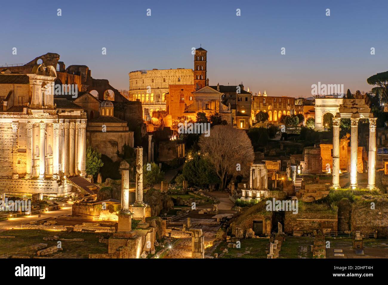 View over the ruins of the Roman Forum in Rome at dawn with the Colosseum in the back Stock Photo