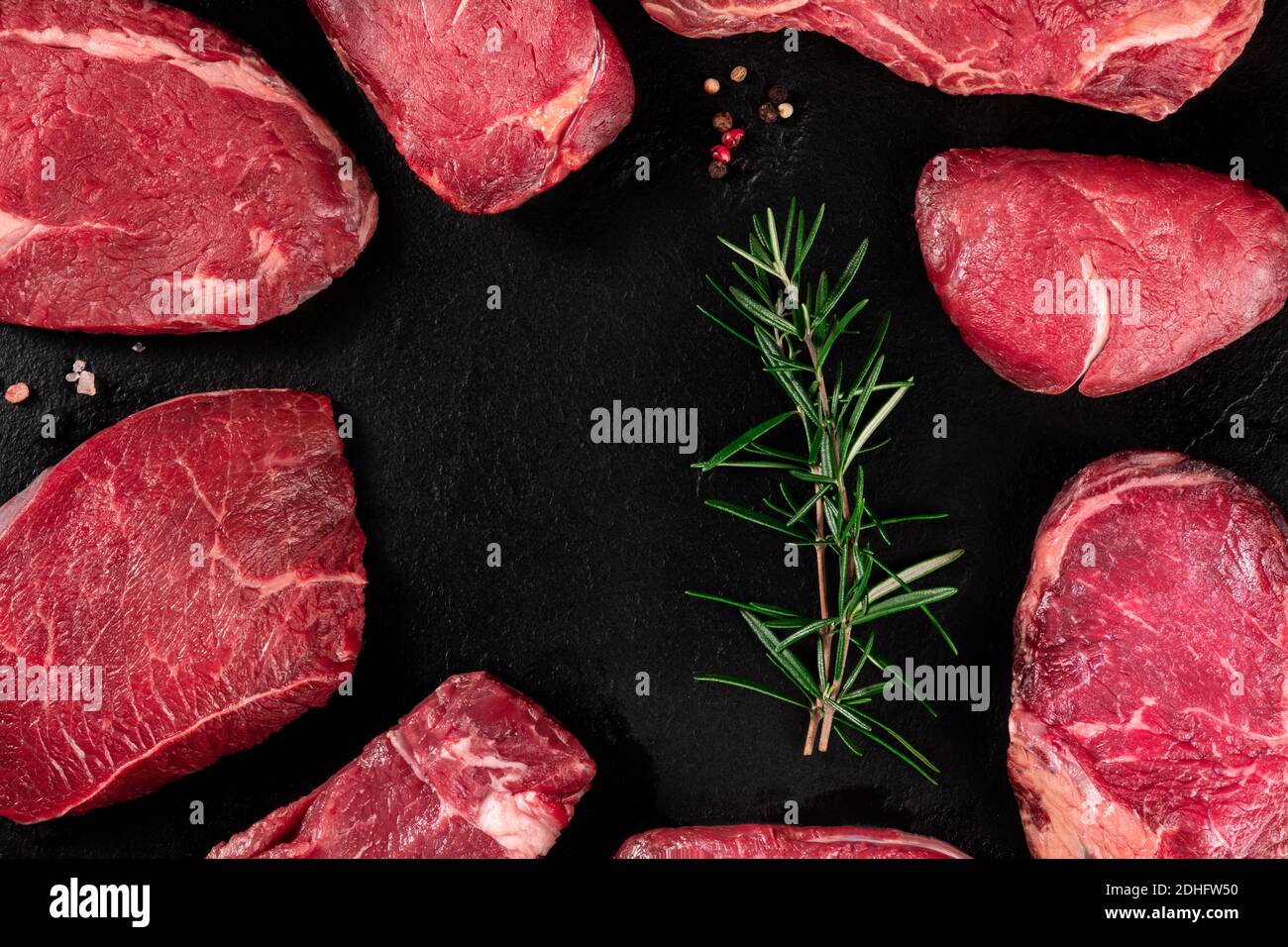 Meat, many different cuts, forming a frame on a dark slate background Stock Photo