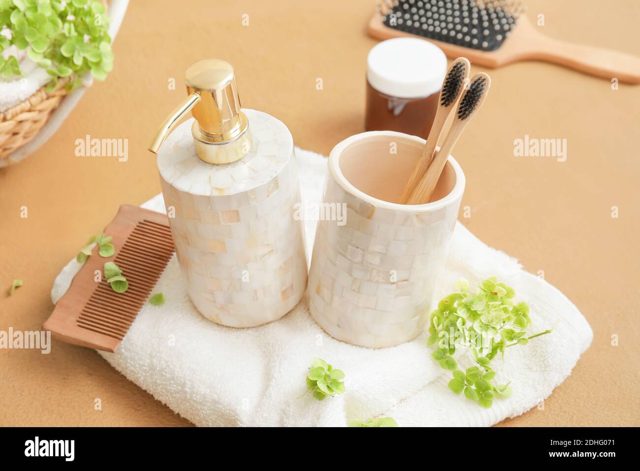 Composition of dispenser and cup with toothbrushes on table Stock Photo ...