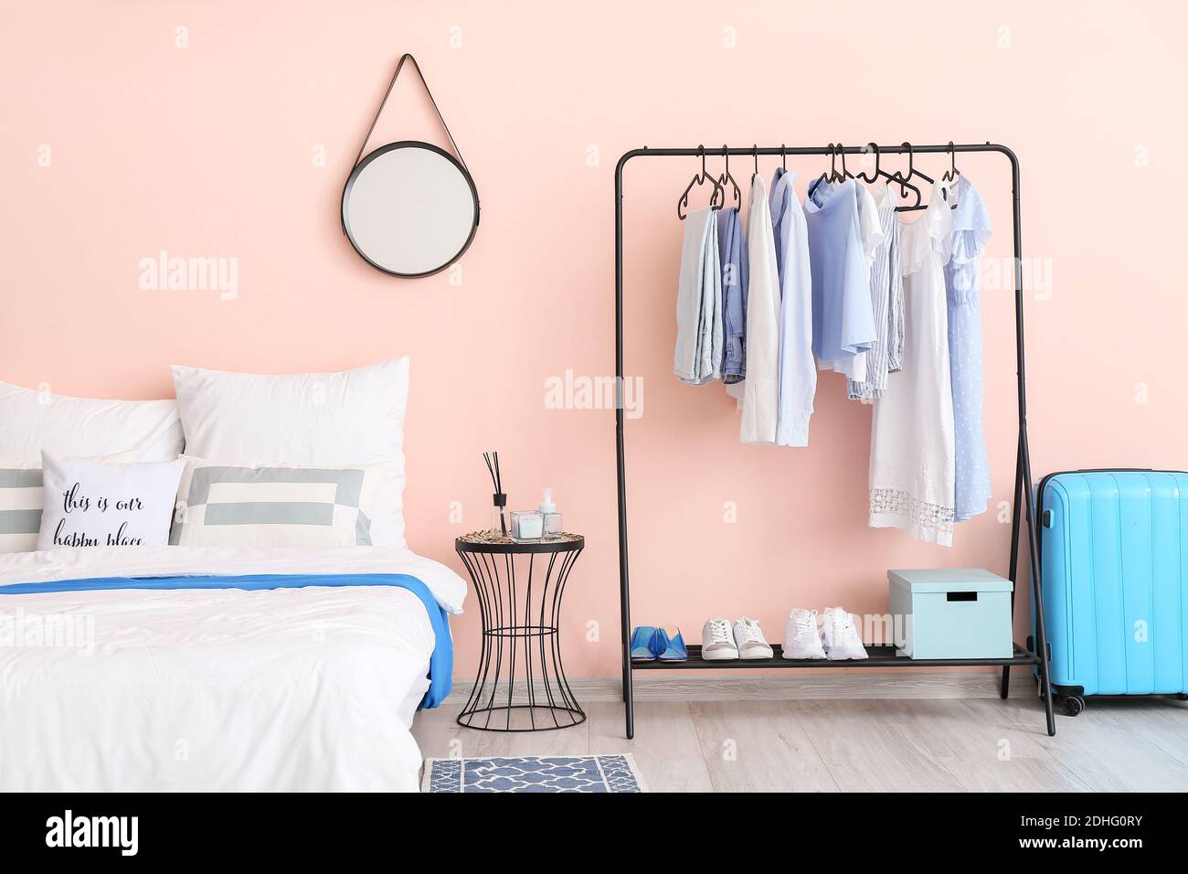 Interior of stylish bedroom with clothes rack Stock Photo Alamy