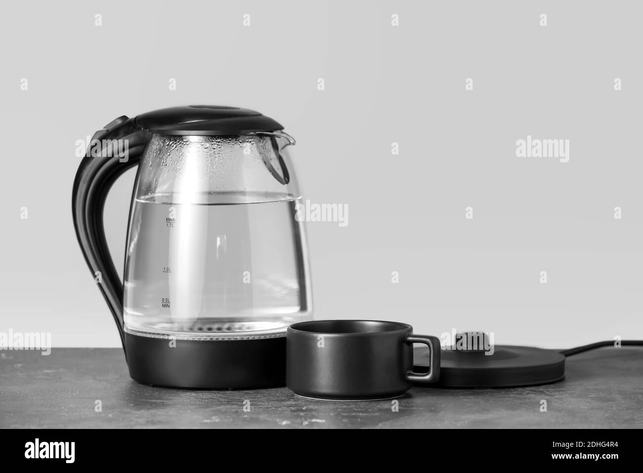 https://c8.alamy.com/comp/2DHG4R4/transparent-electric-kettle-and-cup-on-table-2DHG4R4.jpg