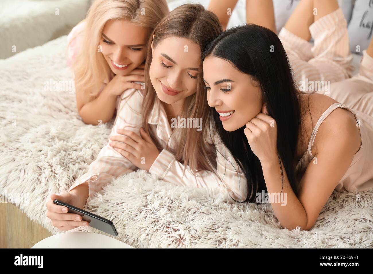 Beautiful young women taking selfie at slumber party Stock Photo