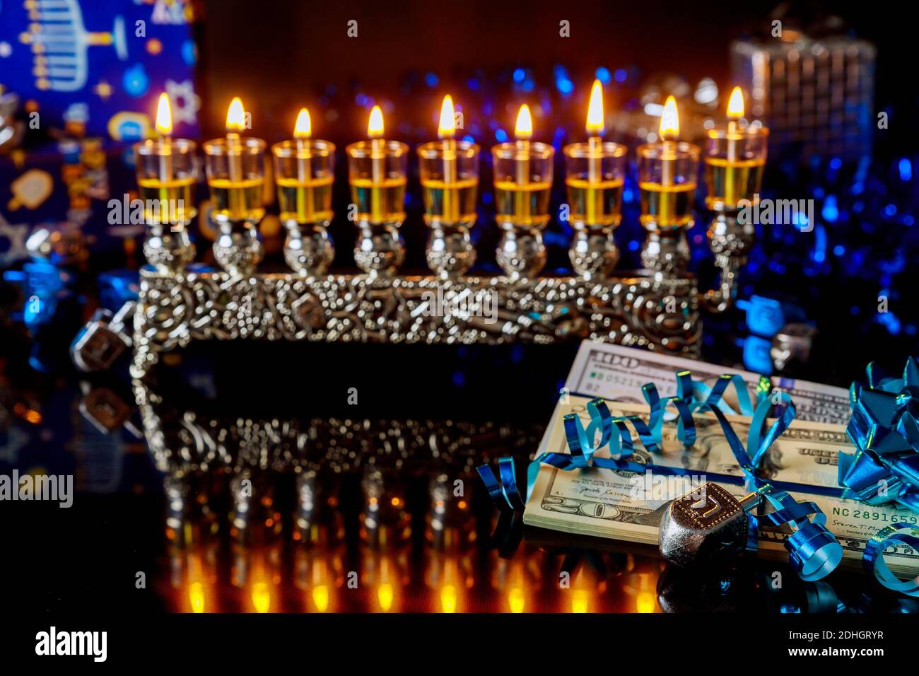 Dollar bill with burning menorah with reflection for Hanukkah. Jewish
