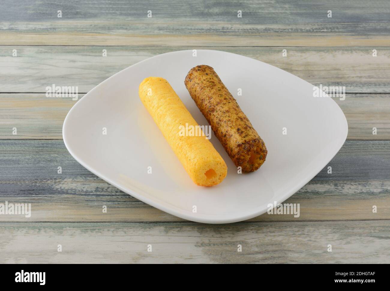 Two Japanese umaibo puffed corn stick snacks on white snack plate on table Stock Photo Alamy