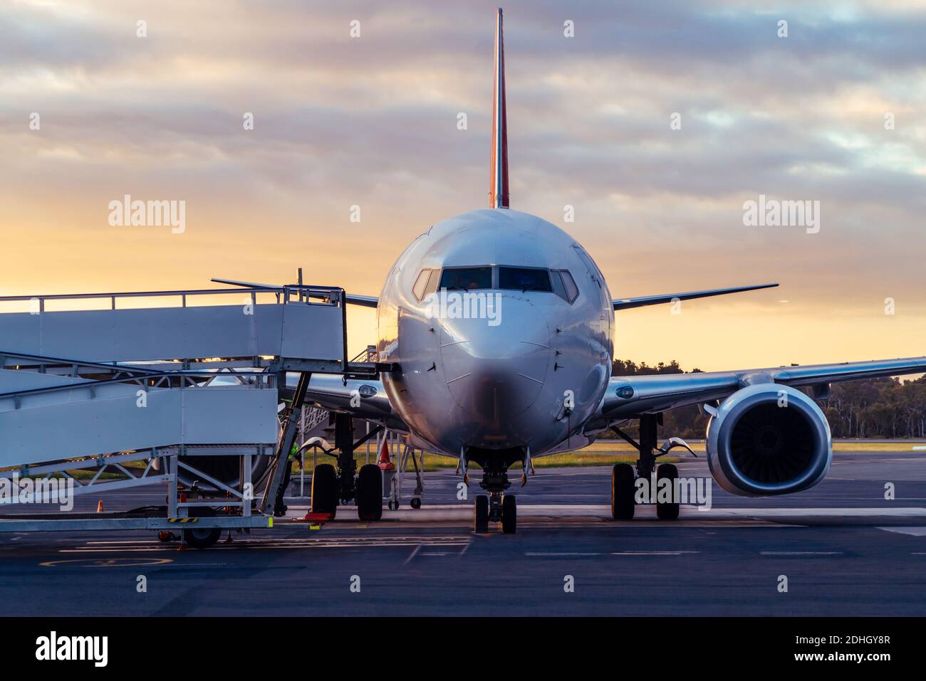 Sunset view of airplane on airport runway under dramatic sky in Hobart,Tasmania, Australia. Aviation technology and world travel concept. Stock Photo