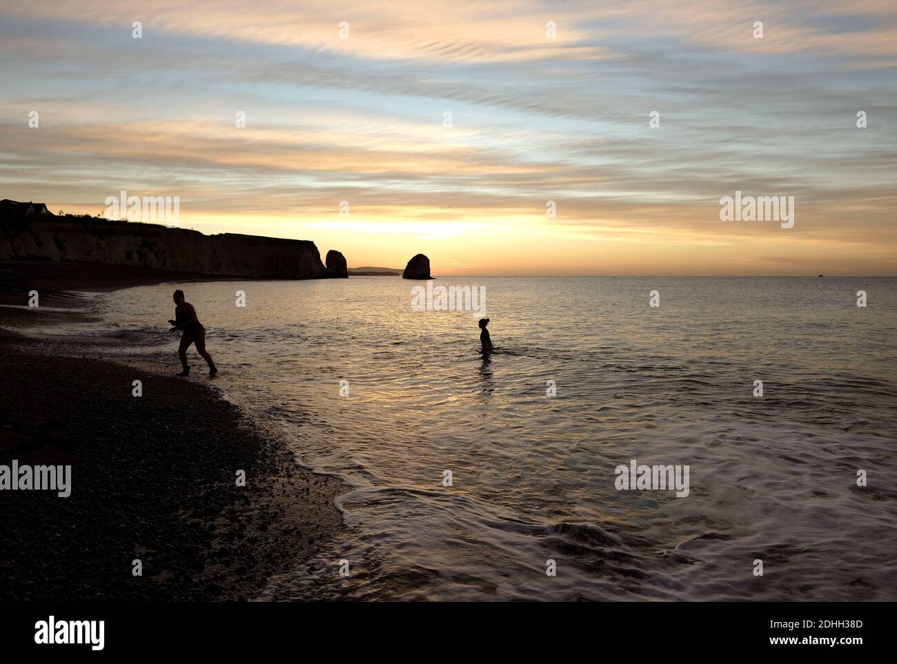 Sunrise wild swimming swimmers in sea at Freshwater Bay Isle of Wight Stock Photo