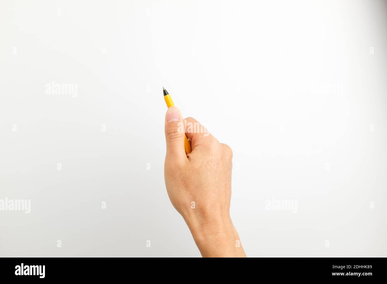 Handwriting posture. Pen gripping. writing. Hand holding an orange pen