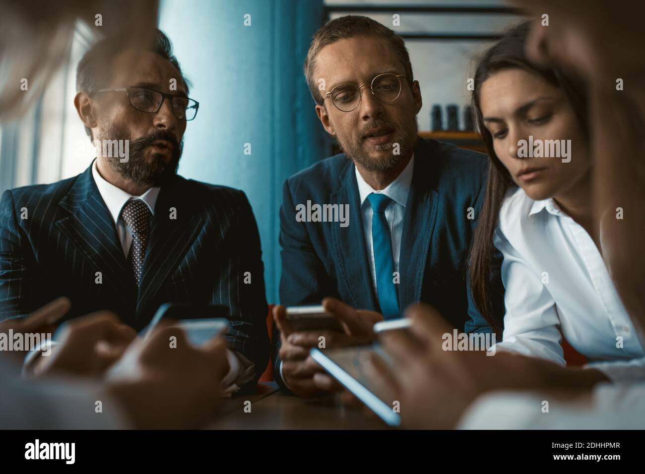 Young team of colleagues app developers testing the bugs of the new app while testing usability with different operation system gadgets. Freelancers Stock Photo