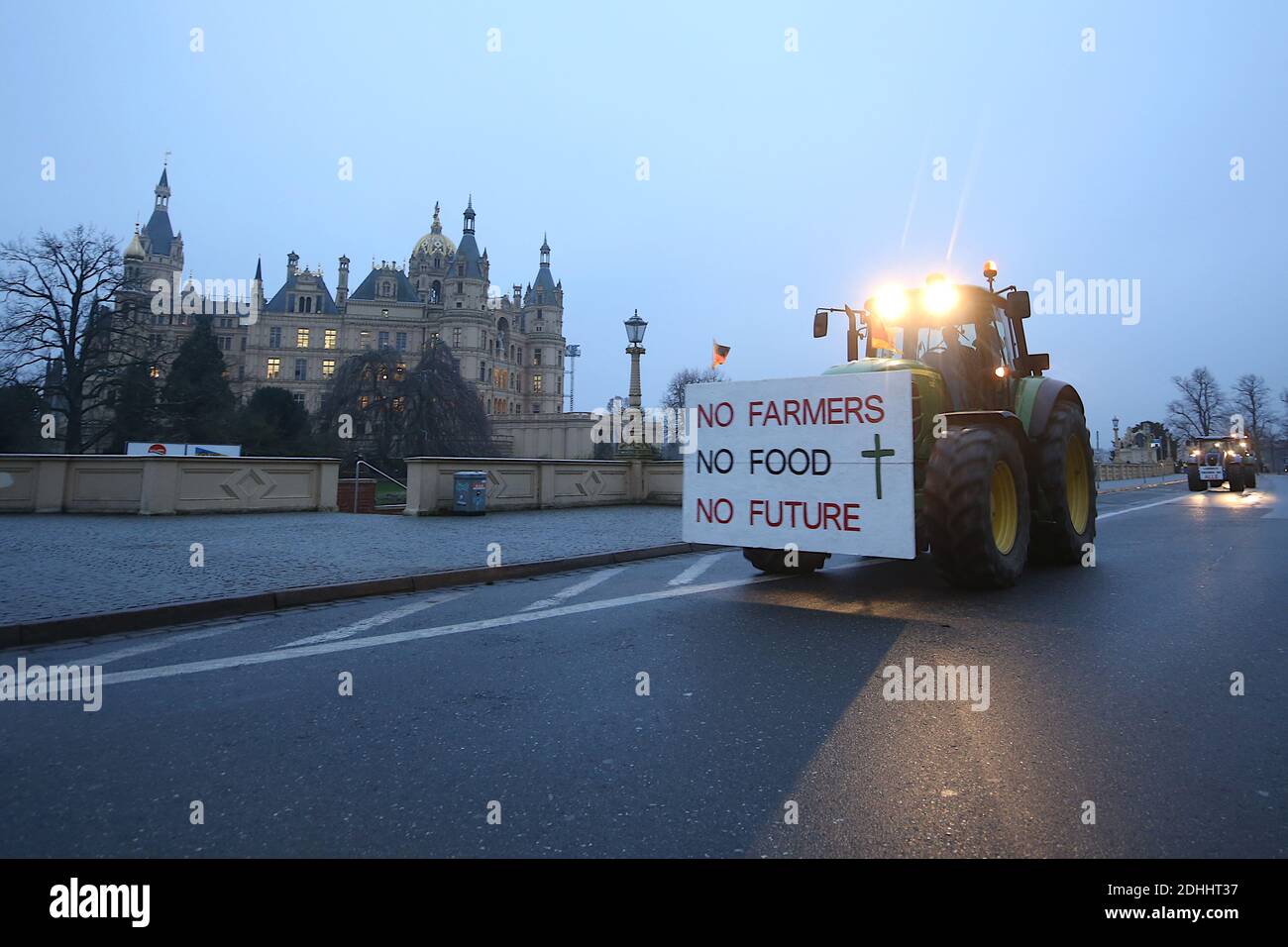 Schwerin, Germany. 11th Dec, 2020. Farmers drive their tractors past the Schwerin castle during a demonstration. A sign with the inscription 'No farmers, no food, no future' hangs on a tractor. The 'Farmers' Association of Mecklenburg-Western Pomerania' and the initiative 'Land schafft Verbindung MV (LSV)' want to use this action to draw attention to the existential threat to agricultural enterprises in Mecklenburg-Western Pomerania together with farmers. Credit: dpa picture alliance/Alamy Live News Stock Photo