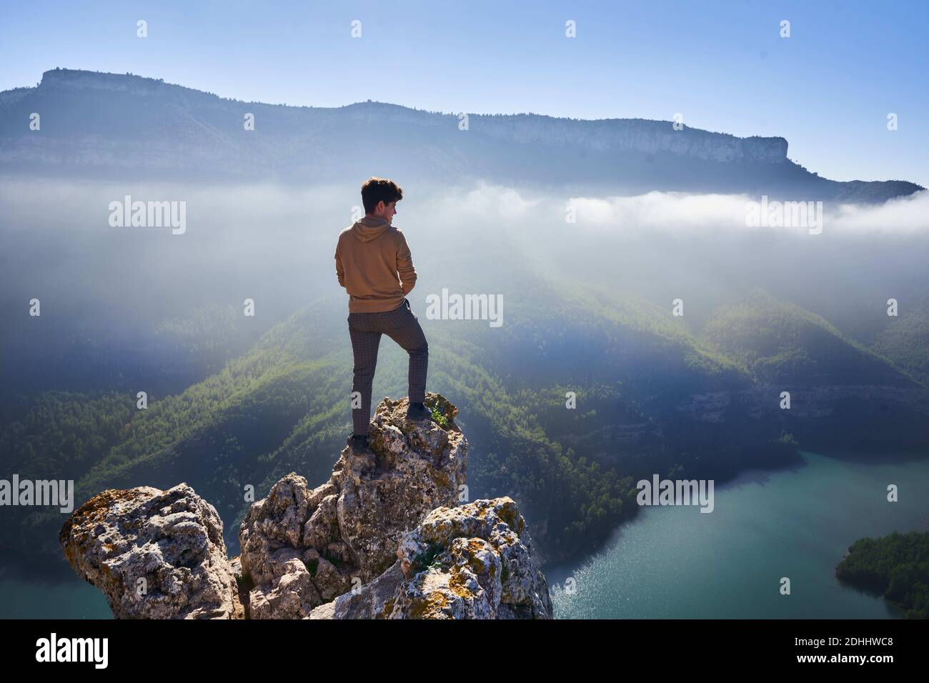 Imagen de un acantilado sobre un rio con niebla al fondo y un hombre observando el paisaje.Tomada en la Comundiad Valenciana, Stock Photo