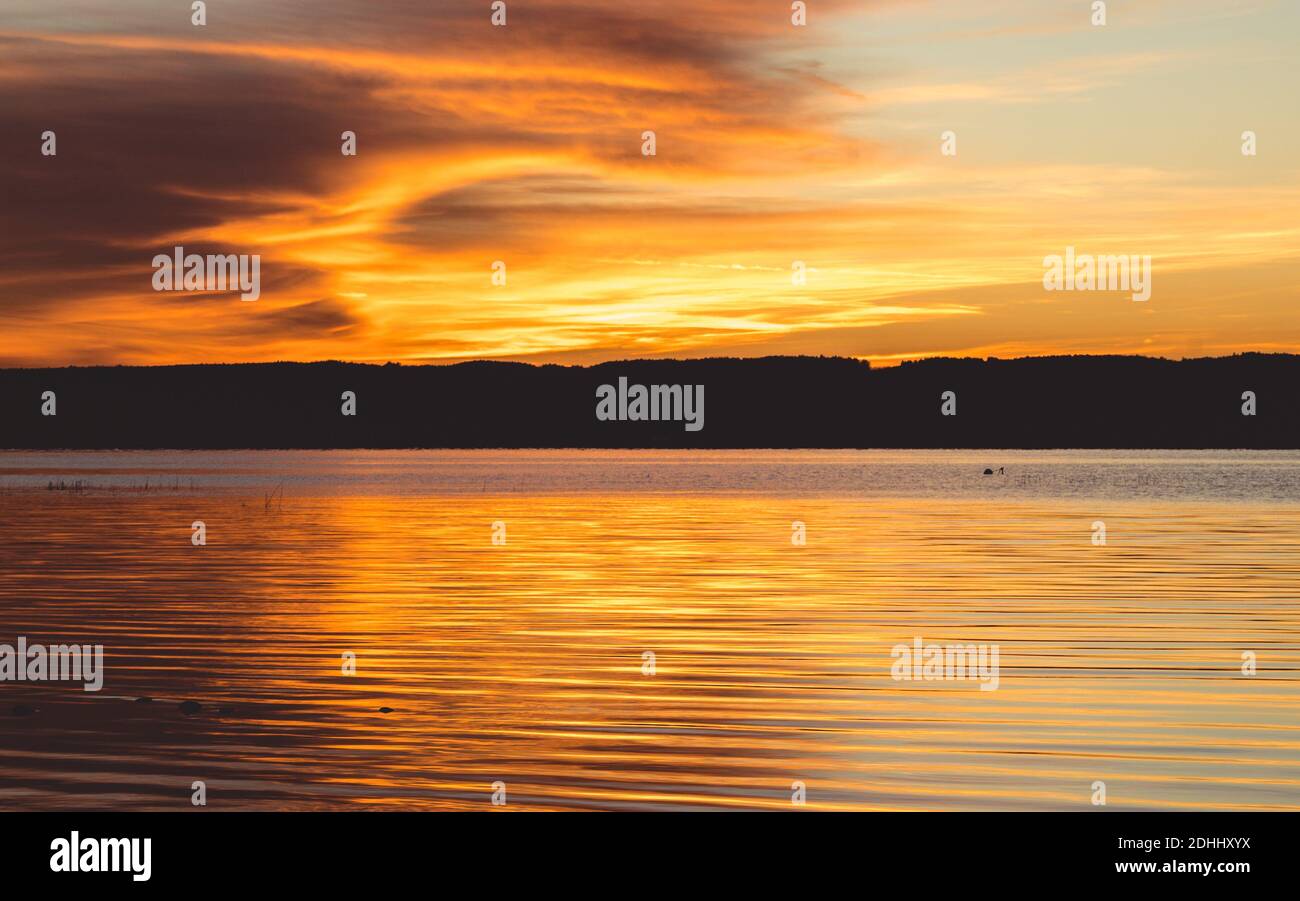 The mesmerizing view of the sunset over the calm sea Stock Photo - Alamy