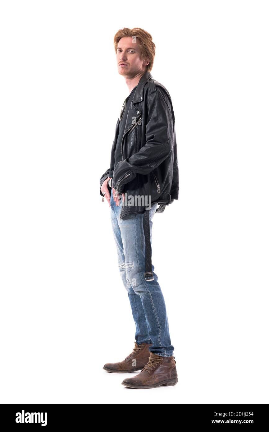 Side view of stylish redhead rocker or biker man with medium length hair posing at camera. Full body length isolated on white background. Stock Photo