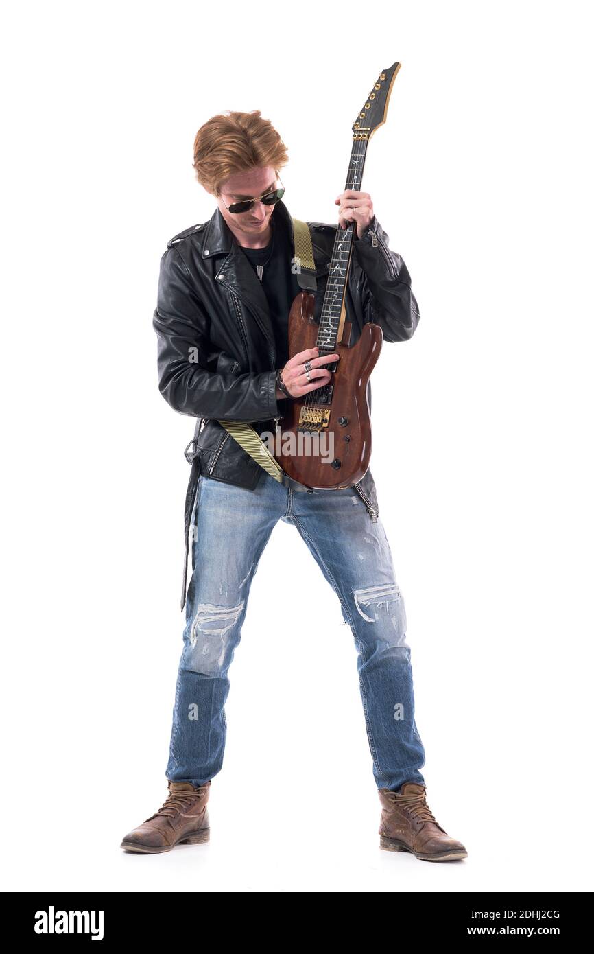 Stylish skilled rocker in black leather jacket playing electric guitar vertically.  Full body length isolated on white background. Stock Photo