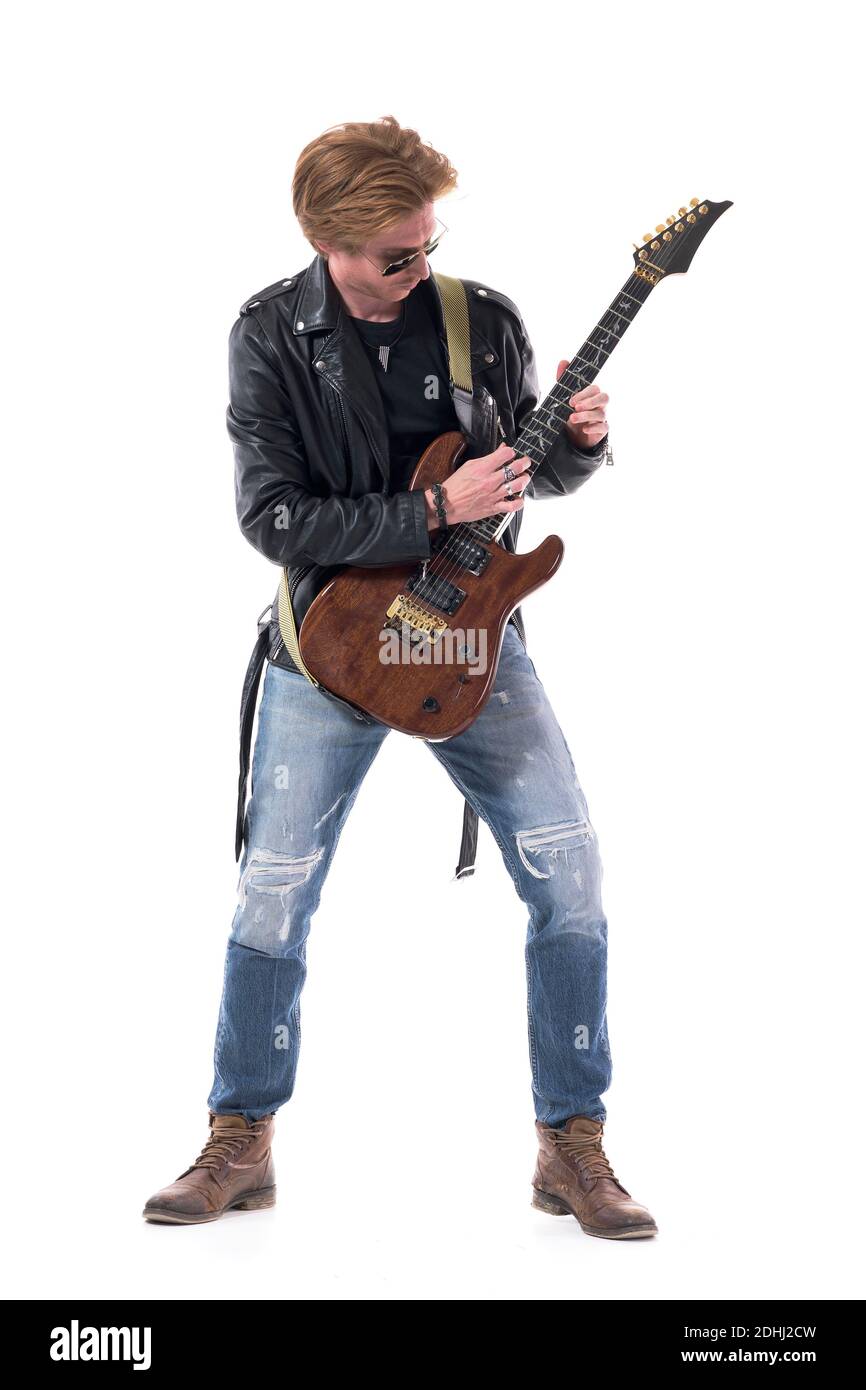 Rock music guitarist playing electric guitar in torn jeans and black leather jacket. Full body length isolated on white background. Stock Photo
