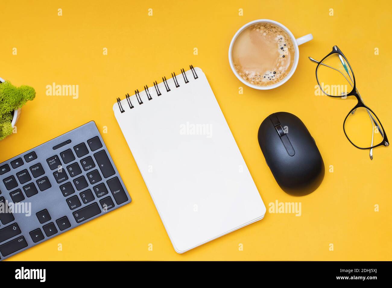 Keyboard, computer mouse and cofffe on yellow background, top view Stock Photo