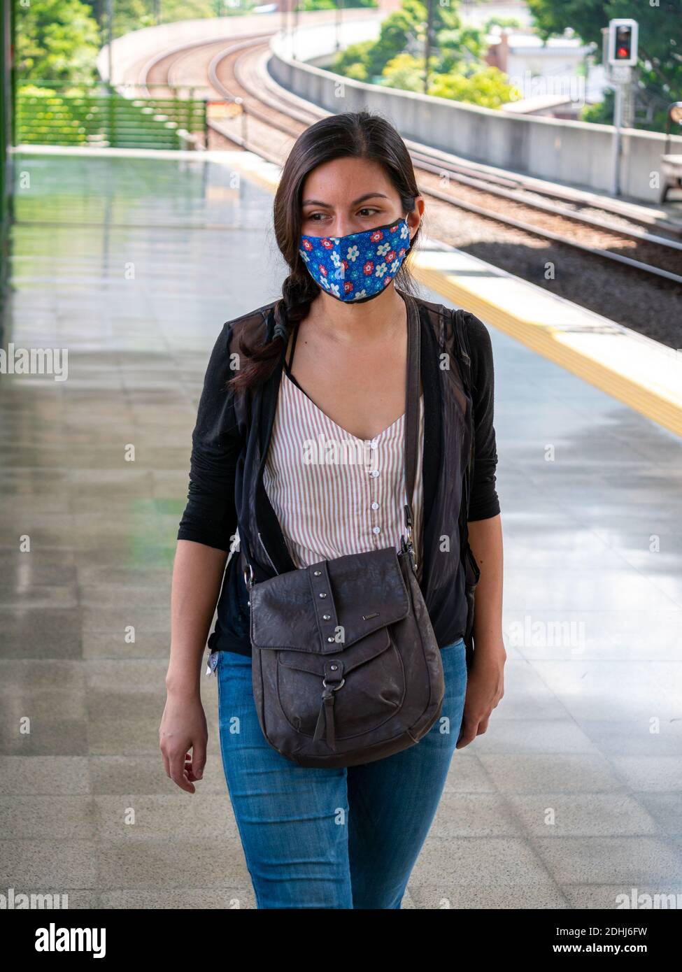 Latin Woman is Wearing a Face Mask and Walking in the Subway Station Stock Photo