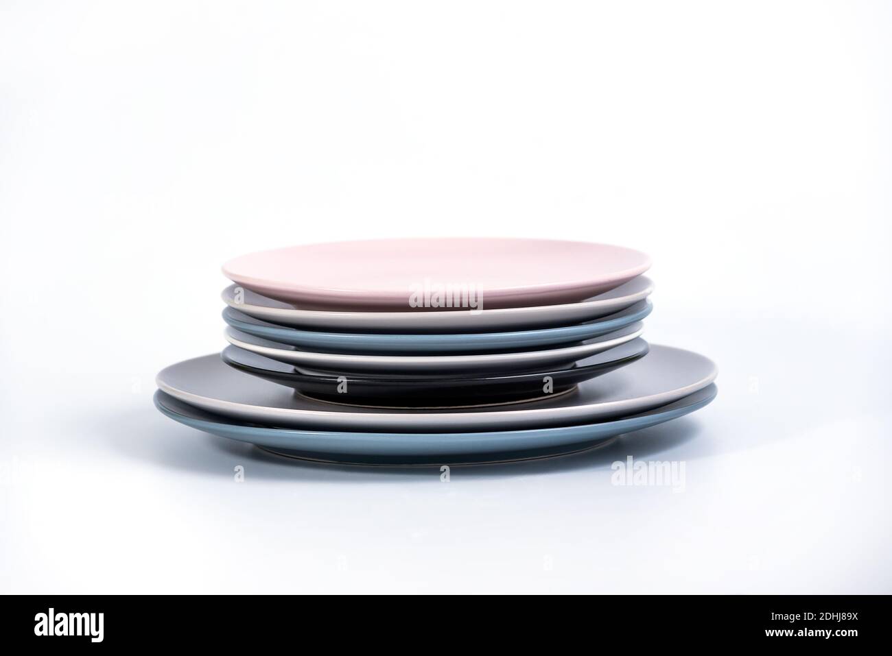 Stack of seven Large and Small colorful empty plates isolated on white ...