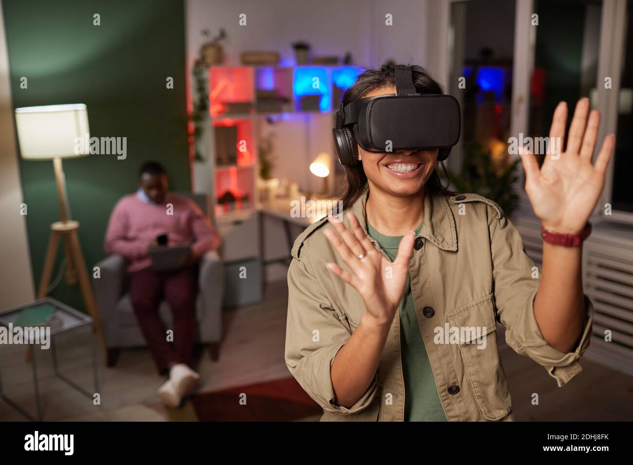 Young woman in VR glasses having fun during break at office Stock Photo
