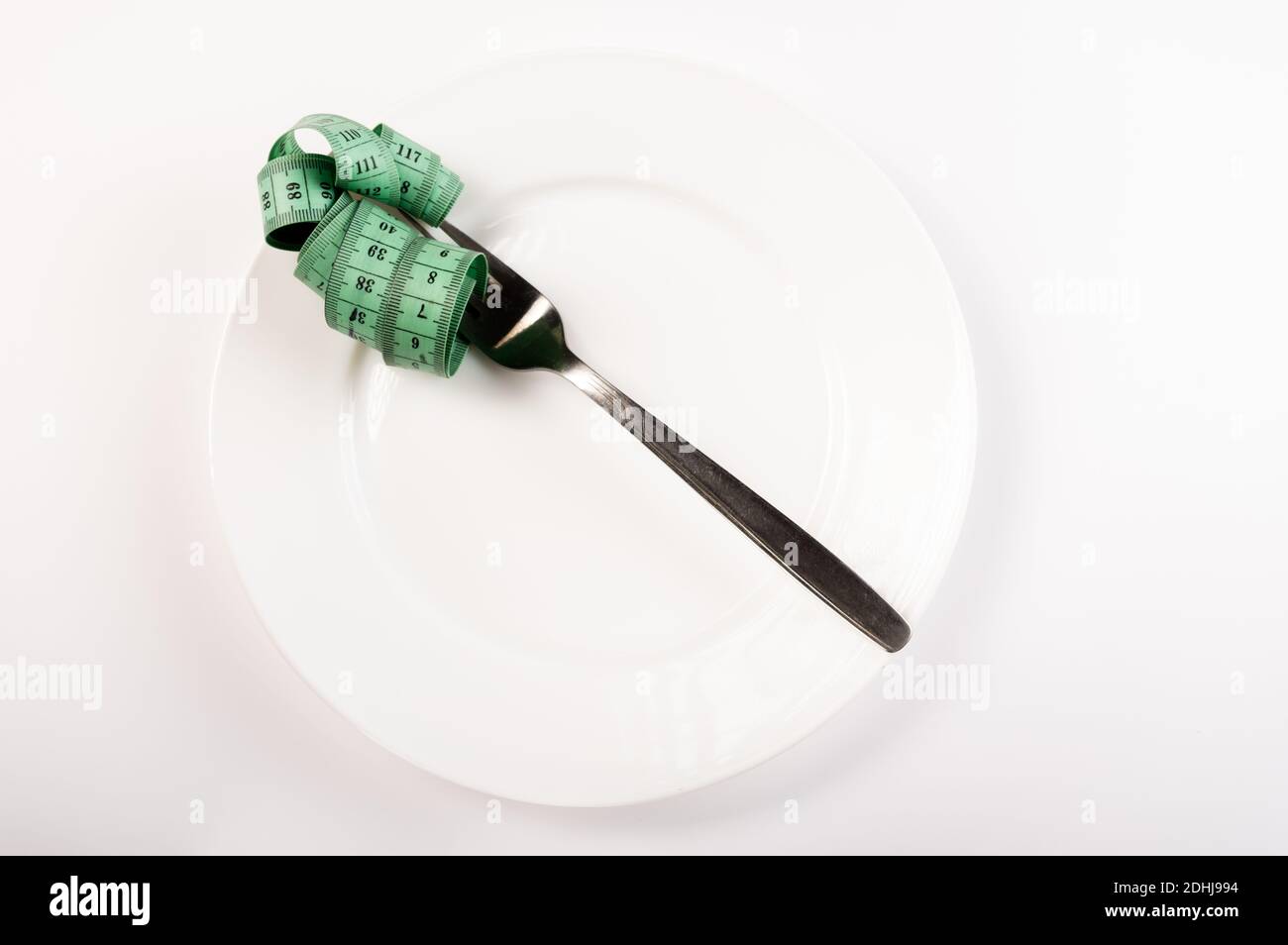 The ruler is wrapped around the fork. Ruler and fork in a white plate ...