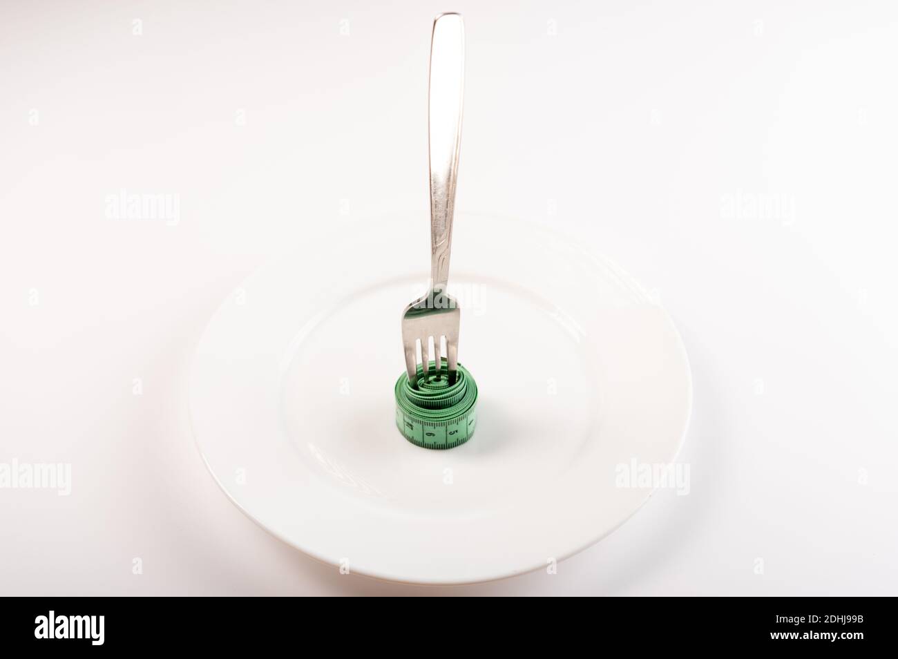 The fork is embedded in a meter ruler. Fork in an empty plate. Isolate ...