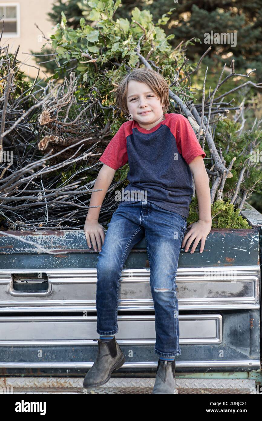 portrait of young boy sitting on old pick up truck Stock Photo