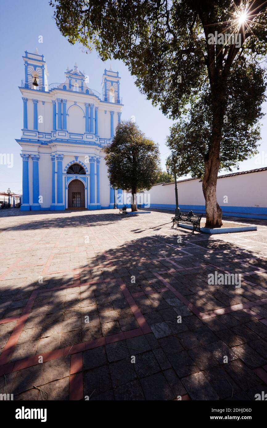 Church in a town square and a shady bench under a tree Stock Photo - Alamy