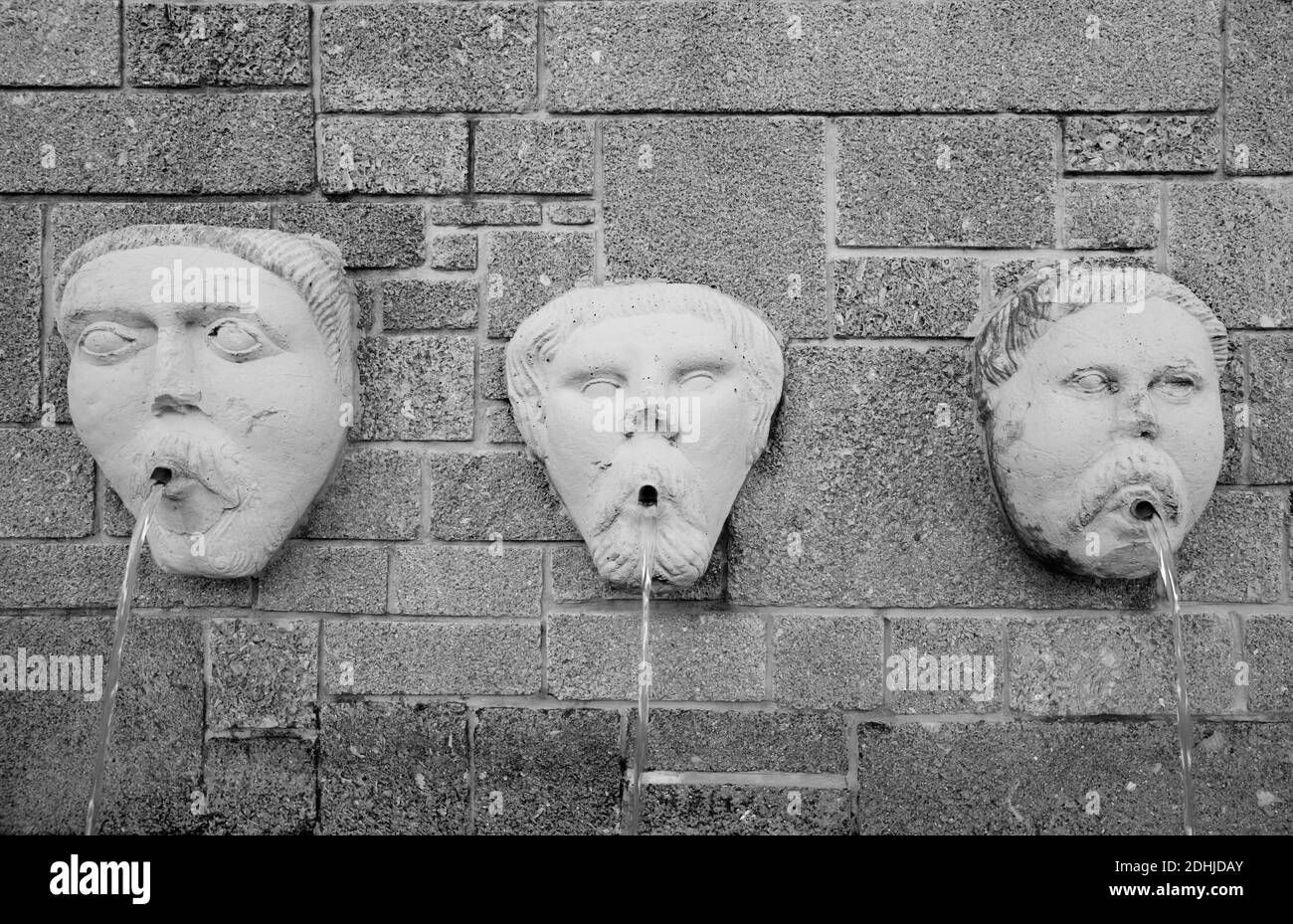 Gargoyle water fountain on stone wall Stock Photo - Alamy