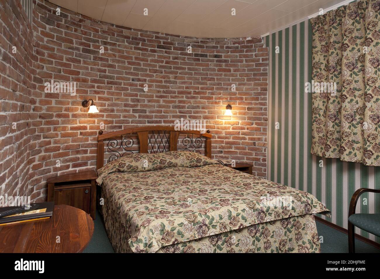 Bed in bedroom with wallpaper and brick wall Stock Photo - Alamy