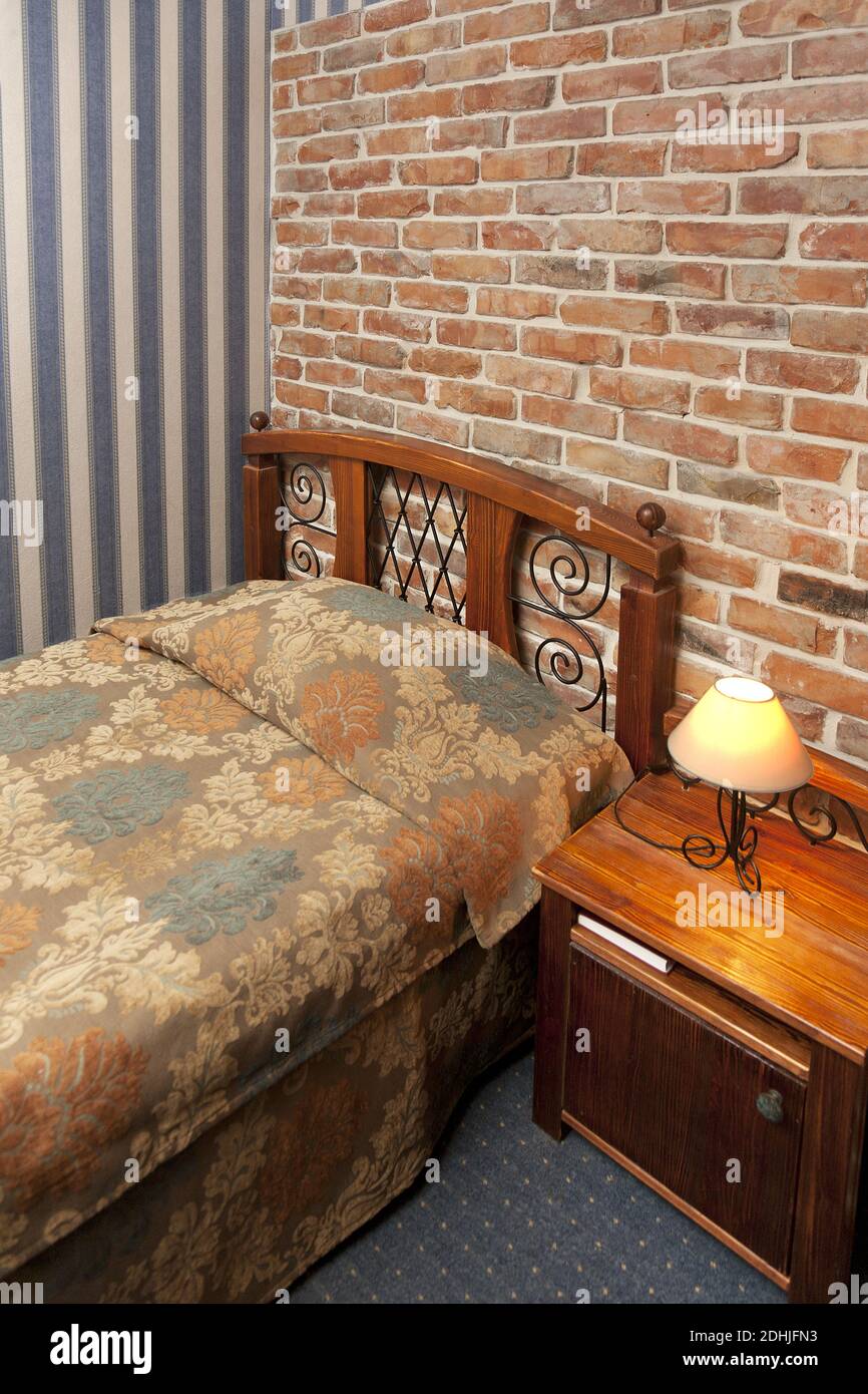 Bed in bedroom with wallpaper and brick wall Stock Photo - Alamy