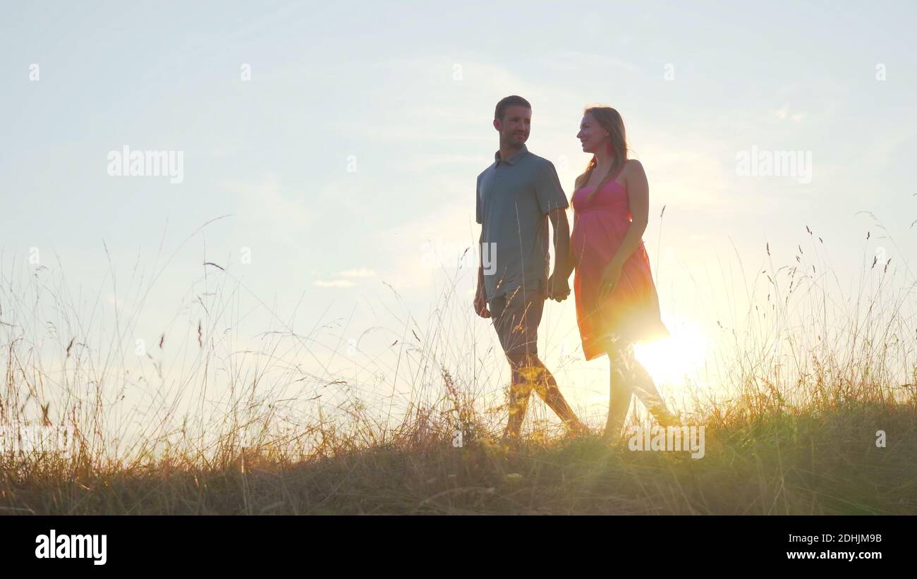 A friendly large family walks across the field at sunset Stock Photo ...