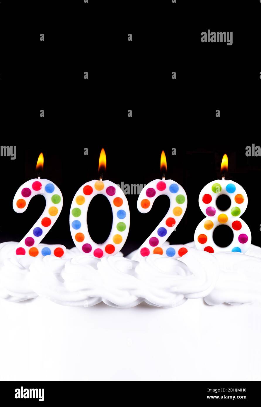 Four white candles numbers flame Happy new year 2028 black background Stock Photo