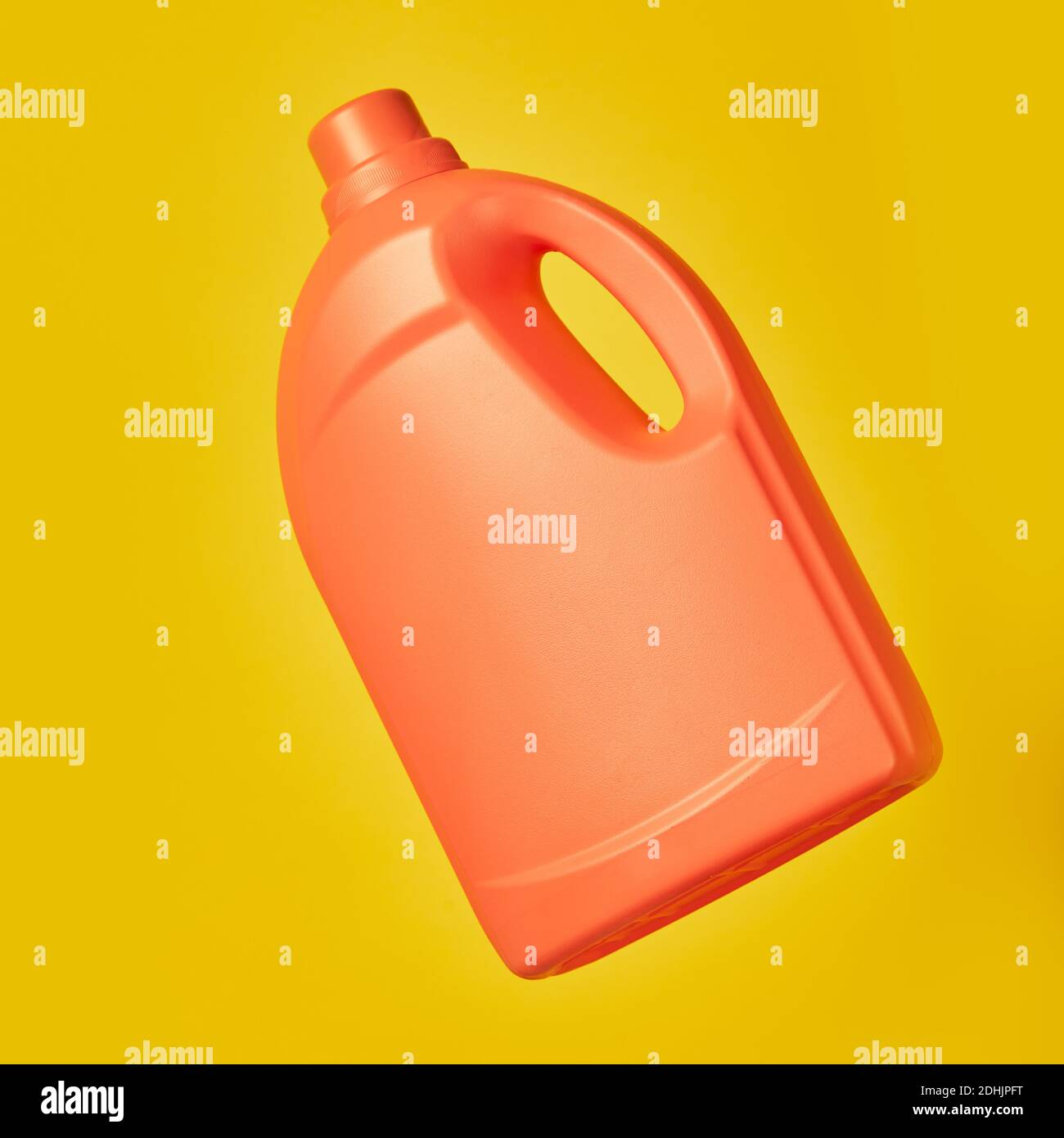 Bright plastic container from liquid detergent placed on vivid yellow background in studio Stock Photo