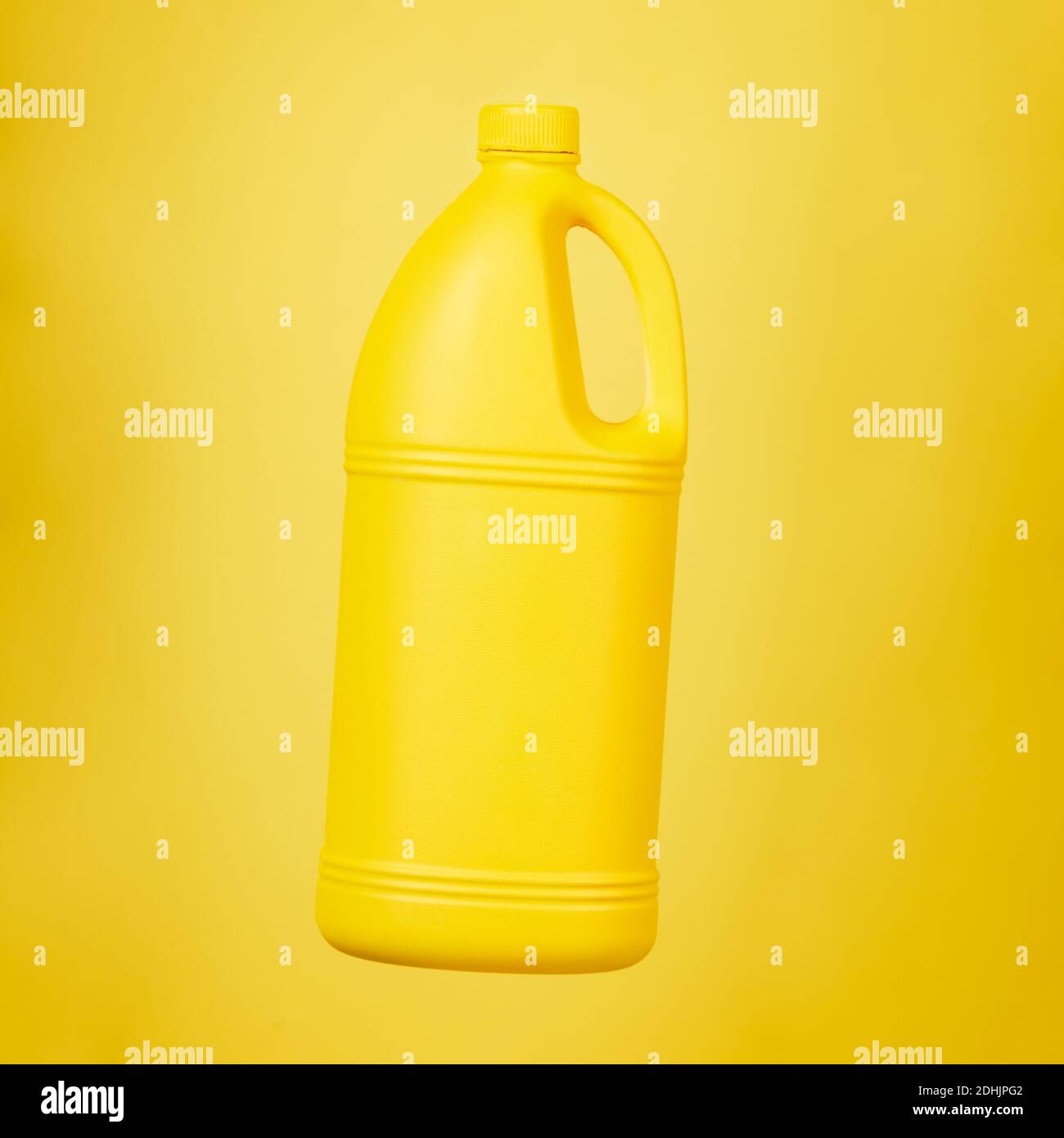 Bright plastic container from liquid detergent placed on vivid yellow background in studio Stock Photo